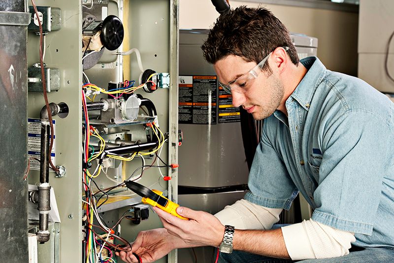 Image of technician working on AC unit. Why Do I Need AC Maintenance Now?