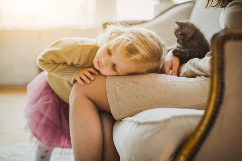 The Basics of Winter Indoor Air Quality. A little girl laying on her moms lap.