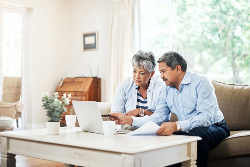 What Do Air Purifiers and Air Filters Do? Senior couple researching together on a laptop in their living room.